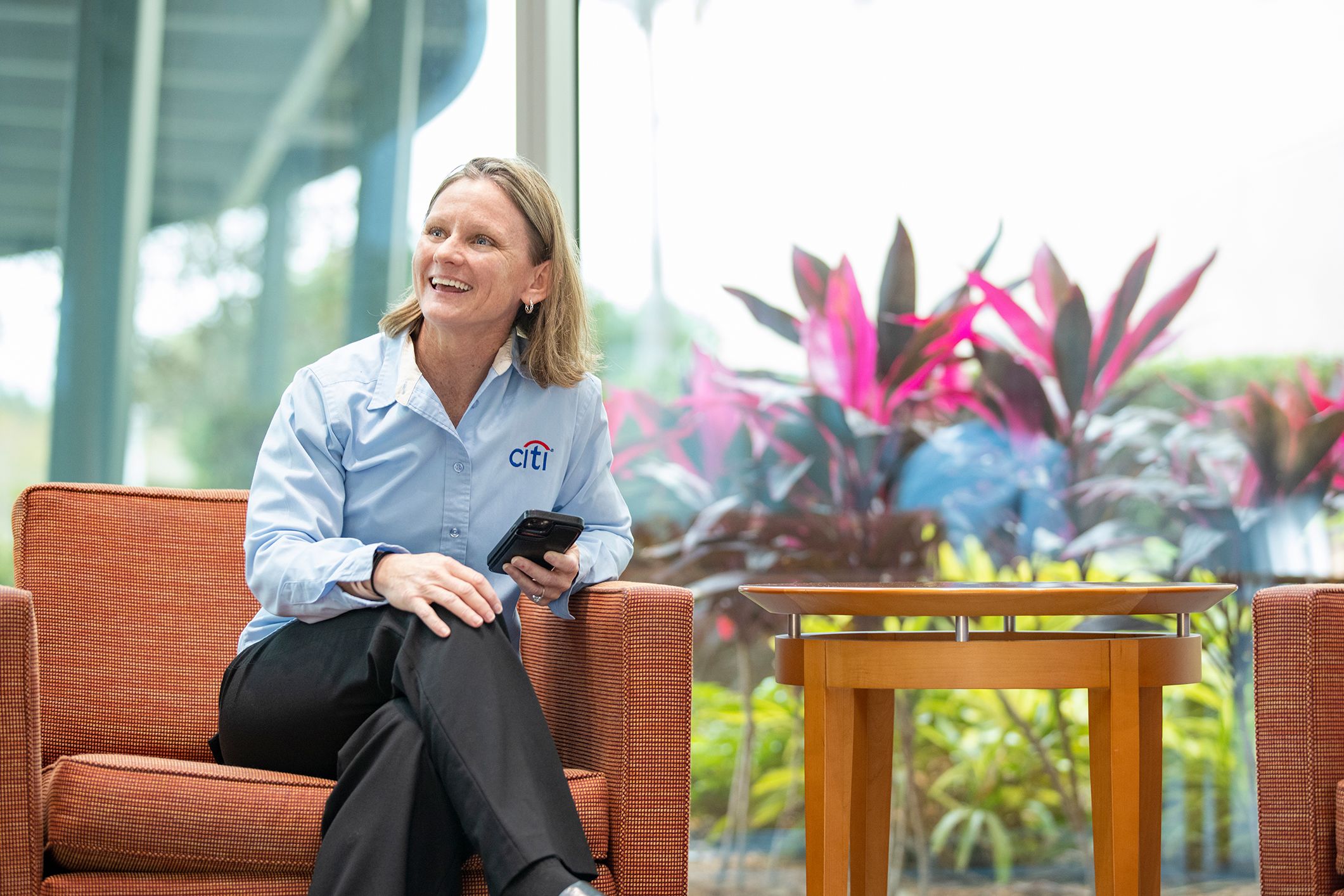 Employee sitting on a sofa chair smiling 