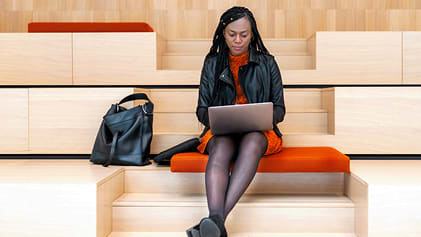 Two children seated on the grass reading a map.